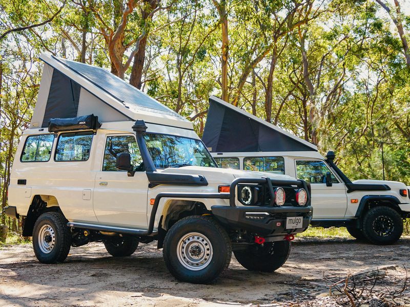 White LandCruiser Troopy with Mulgo Pop Top raised, parked on a bush clearing