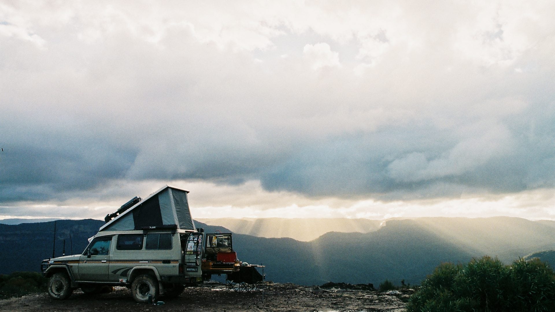 Toyota LandCruiser Troopy with Mulgo pop-top parked on a red desert plain at golden hour